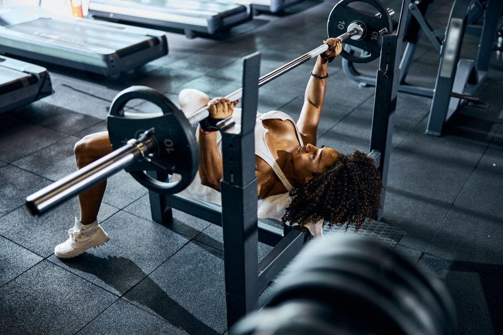 Calm athletic lady performing the bench press